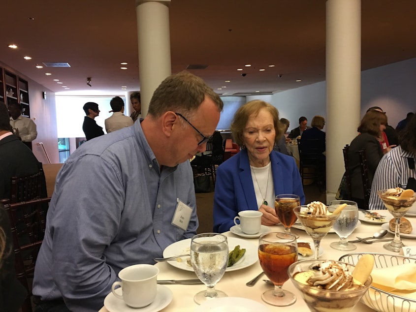 caption: Rosalynn Carter speaks with former KUOW host John Moe at a luncheon for the Rosalynn Carter Mental Health Journalism Fellowship on September 12, 2018.