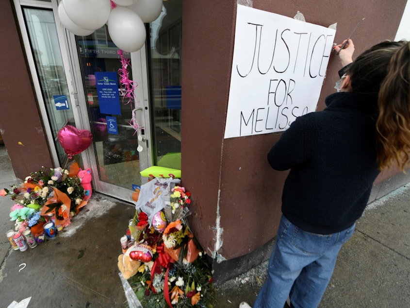 caption: Karla Chavez, of the social activist group Chiactivists, puts up a sign at a memorial for 8-year-old Melissa Ortega in Chicago on Jan, 24. Ortega was walking with her mother in Chicago's Little Village neighborhood on Jan. 22 when she was struck by stray bullets after an unknown offender shot multiple times in their direction.