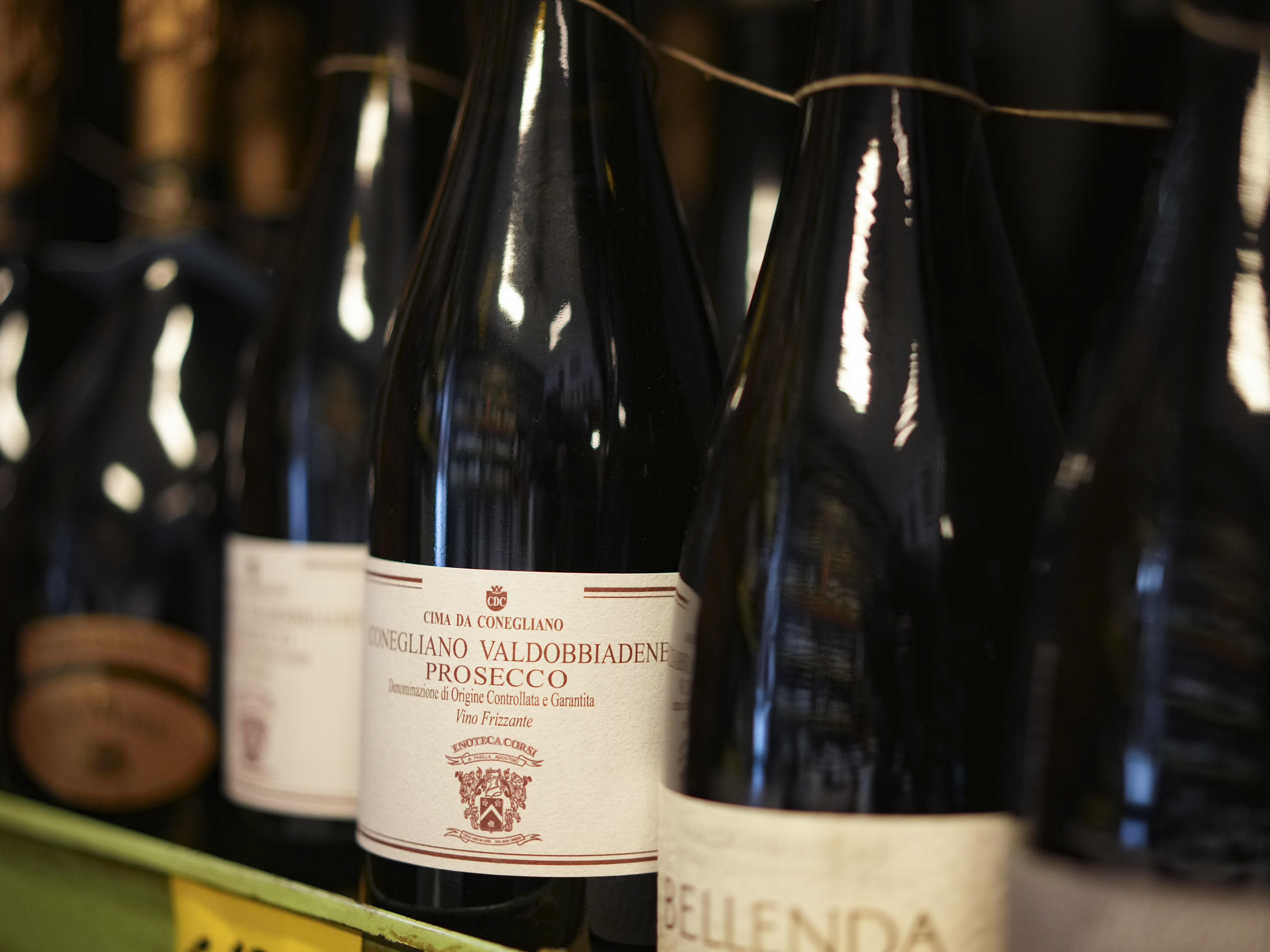 caption: Bottles of Prosecco are lined up on a shelf of a wine shop in Rome last month. Trump's threatened 200% tariffs, if they go into effect, could impact products like imported Prosecco, French champagne and Spanish wine.