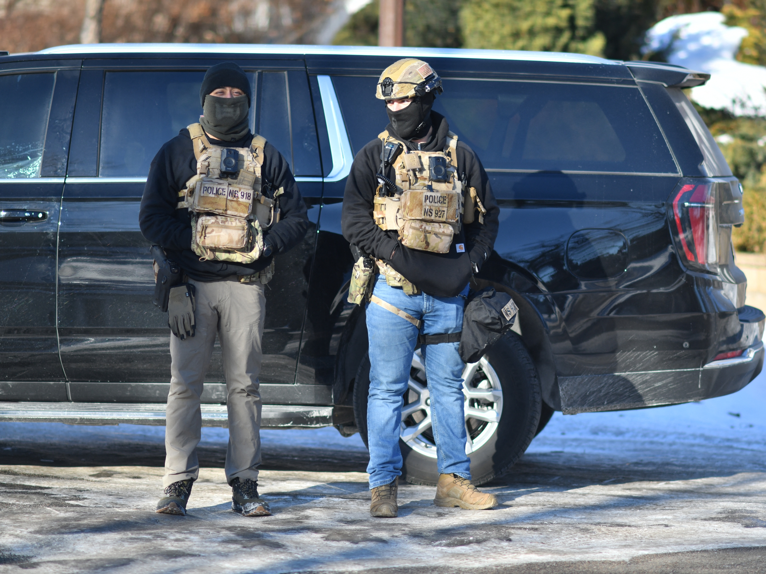 caption: Masked agents stand at an intersection during an ICE immigration enforcement operation in St. Paul, Minn., on Jan. 31. Some employees of Thomson Reuters, which has a major presence in the Twin Cities, became concerned about the company's contracts to supply data to ICE as the Trump administration's immigration surge in Minnesota intensified.