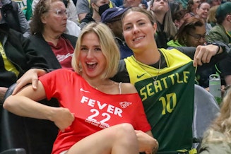 caption: Ashley Sams (right) and AJ Guller (left) watch the Seattle Storm take on the Indiana Fever Wednesday, May 23, 2024. Guller says she's a Seattle Storm fan unless Caitlin Clark is playing on the court. 
