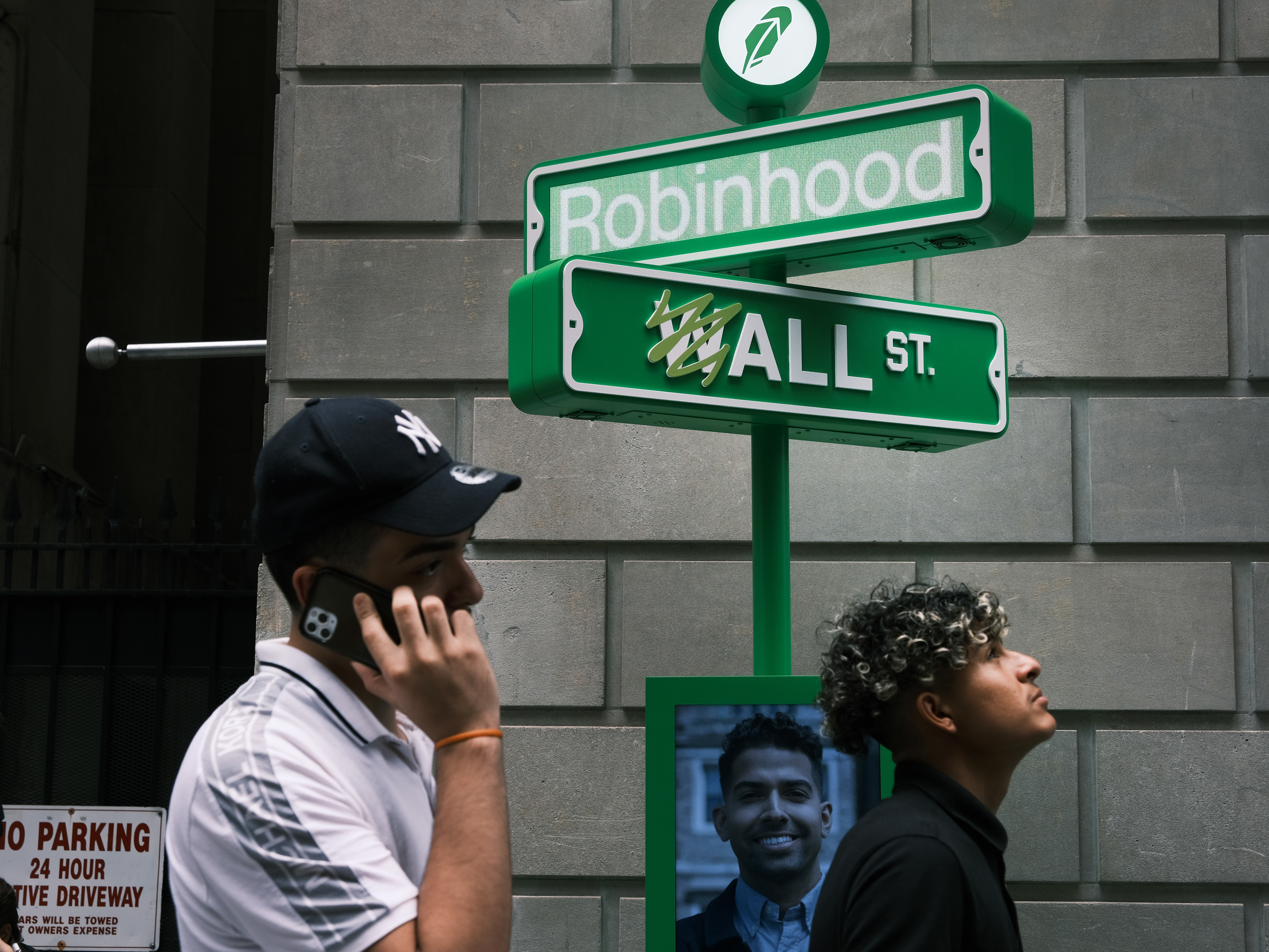 caption: People wait in line for T-shirts at a pop-up kiosk for the online brokerage Robinhood in New York City after the company went public on July 29, 2021. On Tuesday, the company said it was cutting nearly a quarter of its staff.