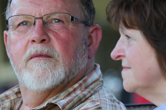 caption: Ron and Gail Thompson outside their new home in the Oso area.