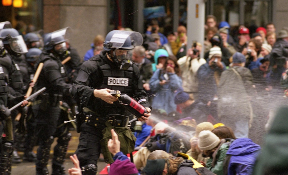 caption: Police spray pepper spray at protesters, WTO Protests in Seattle, November 30, 1999.