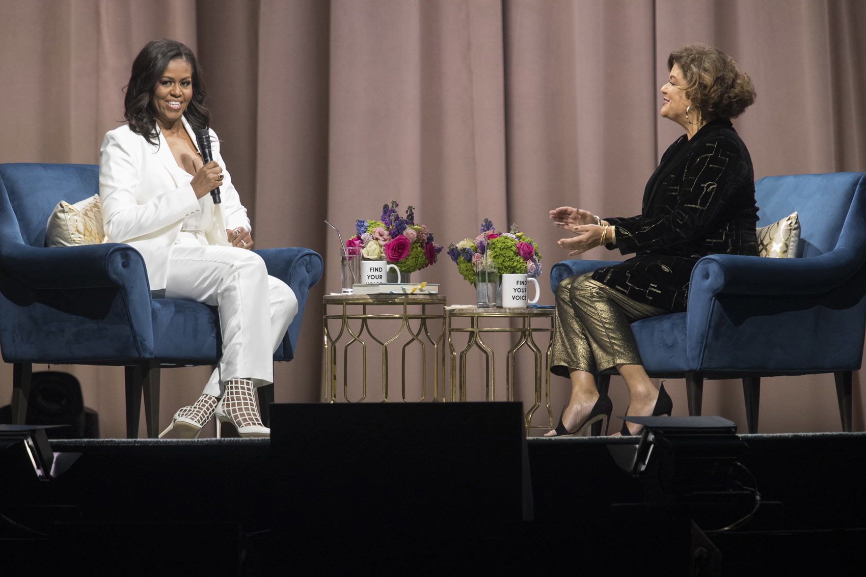 caption: Former first lady Michelle Obama, left, is interviewed by Elizabeth Alexander during the "Becoming: An Intimate Conversation with Michelle Obama" at Barclays Center in Saturday, Dec. 1, 2018, in New York. (Mary Altaffer/AP)