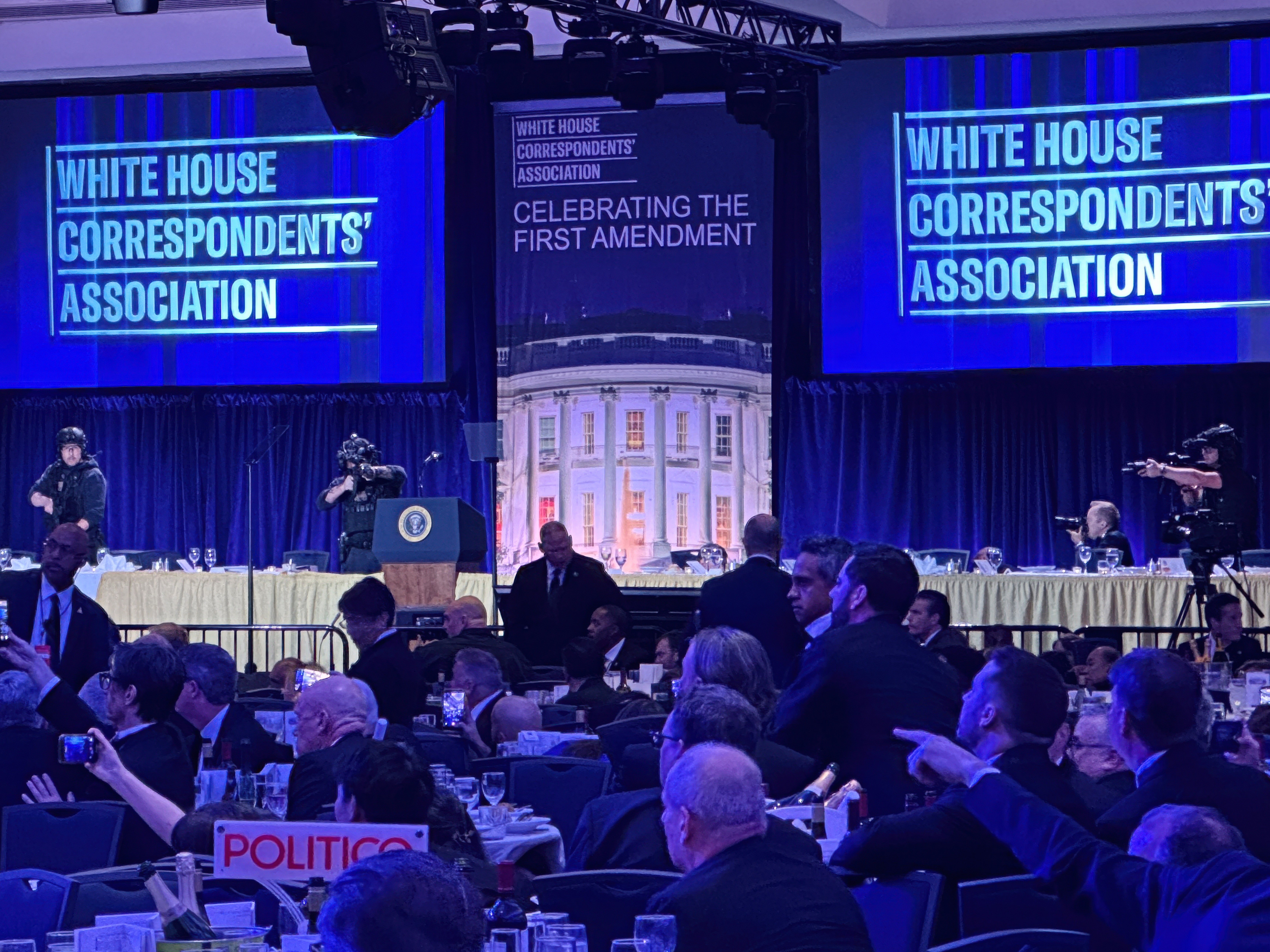 caption: Members of the U.S. Secret Service counter assault team stand on the stage after a shooting incident outside the ballroom during the White House Correspondents Dinner on April 25 in Washington.