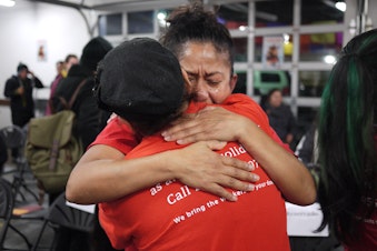 caption: Sylvia Gonzales hugs a friend after President Obama's immigration announcement