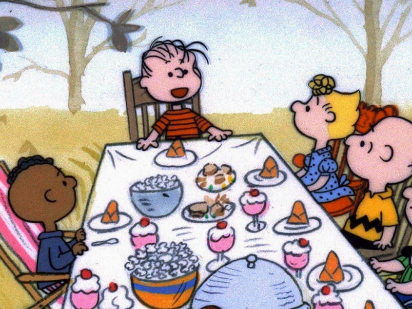 caption: The <em>Peanuts</em> gang celebrates Thanksgiving, but why is Franklin by himself on one side of the table?