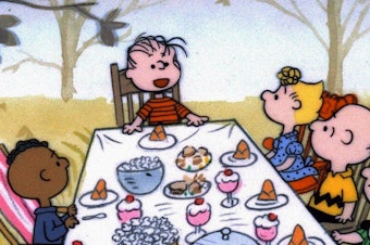 caption: The <em>Peanuts</em> gang celebrates Thanksgiving, but why is Franklin by himself on one side of the table?
