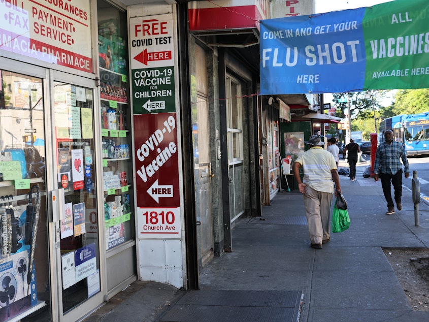 caption: Lab data suggests the new COVID-19  booster shots should protect against a variant that concerns scientists. The boosters should be widely available this fall at pharmacies, like the one seen in the Flatbush neighborhood of Brooklyn borough in New York City.