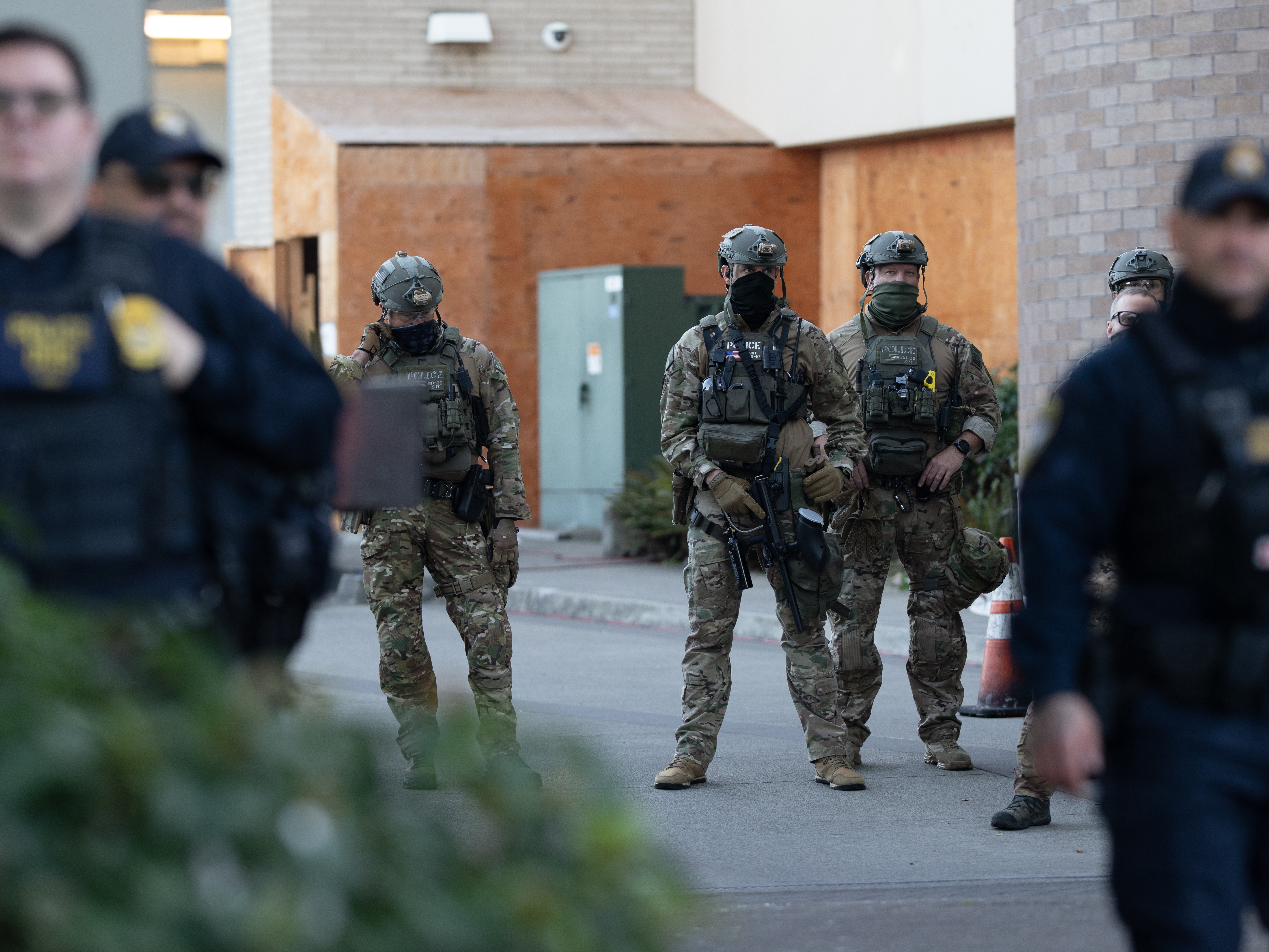 caption: Law enforcement officers look out from a United States Immigration and Customs Enforcement (ICE) facility Oct. 21, 2025, in Portland, Ore.
