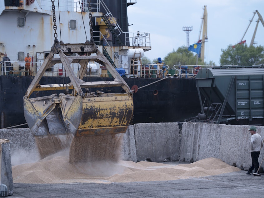 caption: Workers load grain at a port in Izmail, Ukraine, on April 26. A United Nations-backed deal has been extended allowing shipments of Ukrainian grain through the Black Sea to parts of the world struggling with hunger.