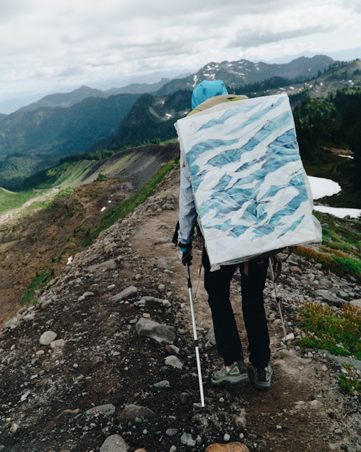 caption: Artist Claire Giordano carries all her materials with her on her expeditions, including a full canvas when needed.