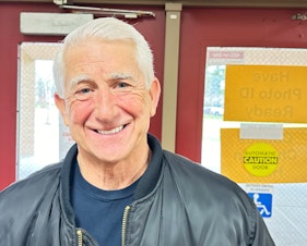 caption: Dave Reichert after firing up a crowd of fellow Republicans at Kamiakin Middle School in Kirkland, wearing his old leather King County Sheriff's jacket.