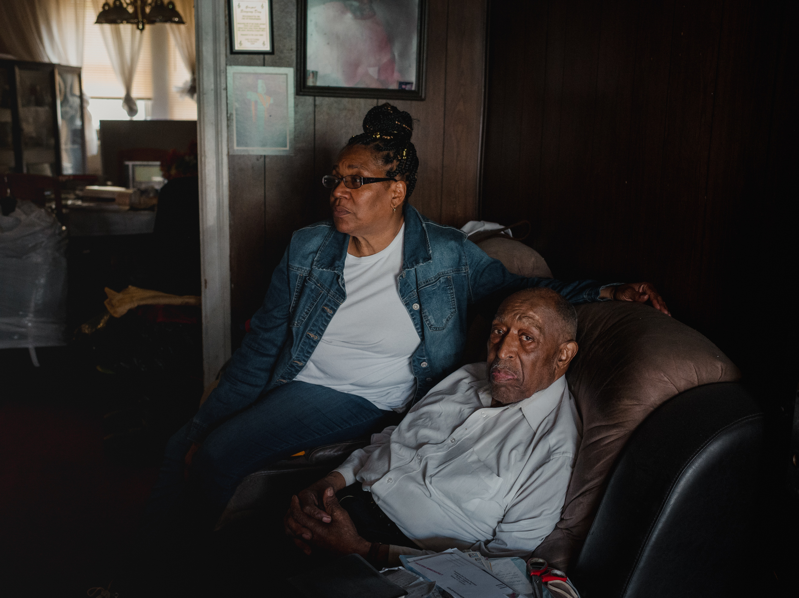 caption: Veronica Stovall, left, helped her father, Joseph L. Davis, apply for a federally-funded energy-efficiency program in 2021. It turned up significant repair needs.