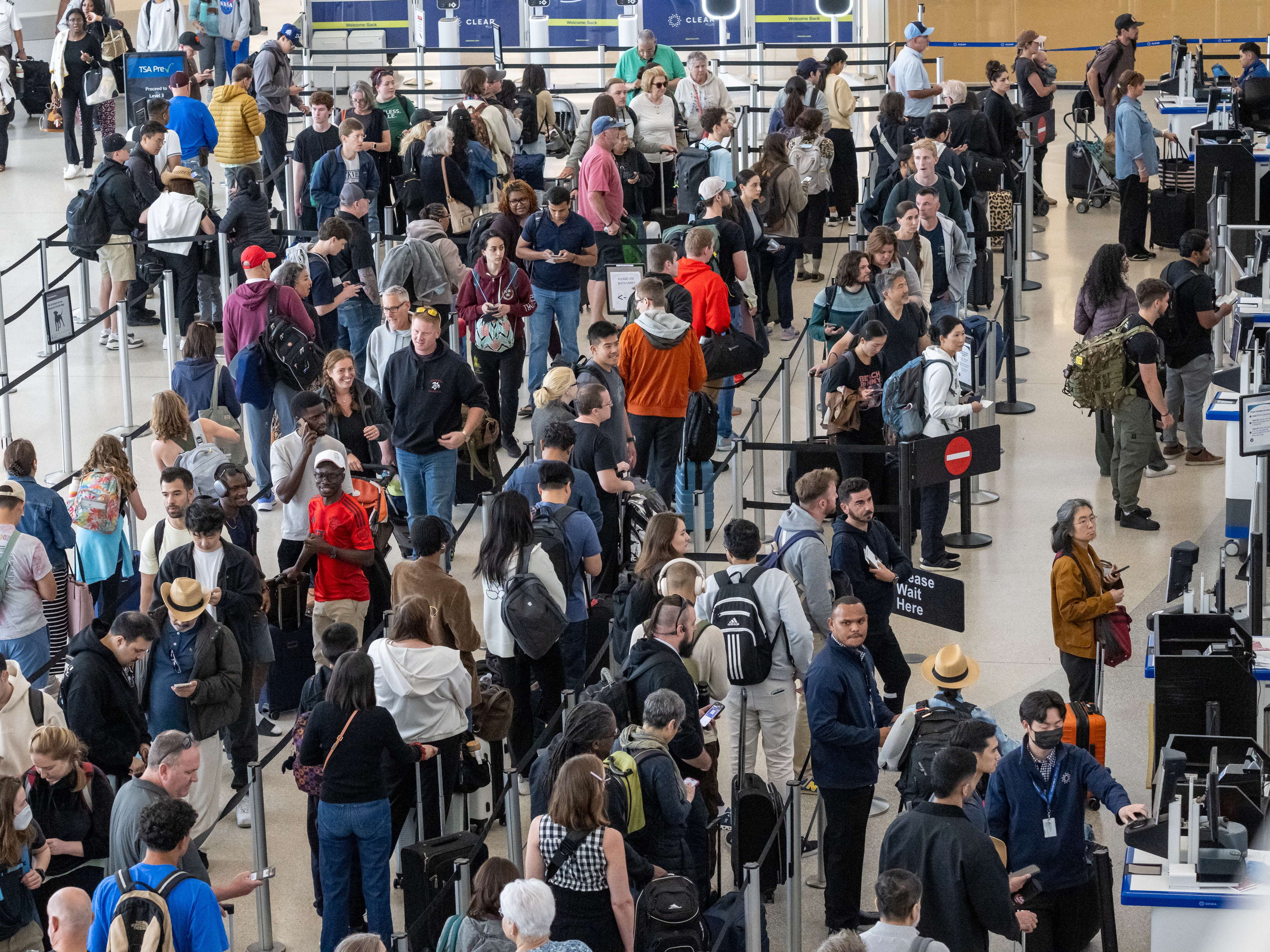 caption: Travelers go through security at San Francisco International Airport the Friday before Memorial Day. AAA predicts Fourth of July weekend will be even busier.