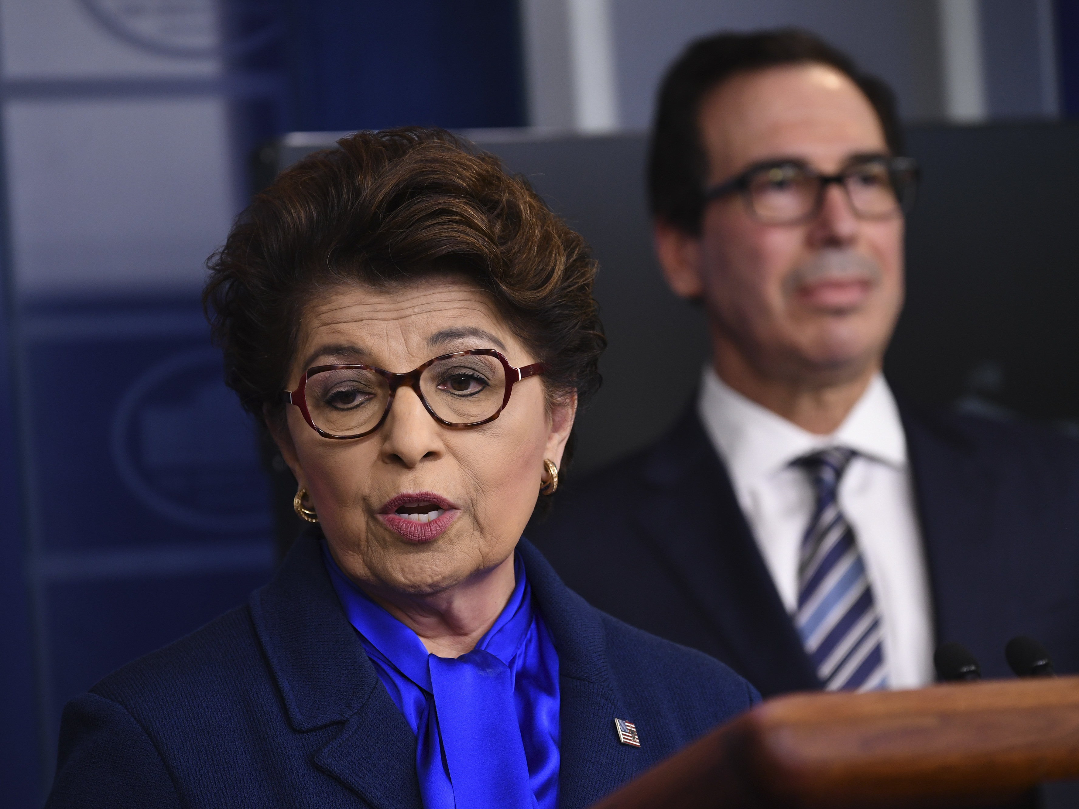 caption: Jovita Carranza, head of the Small Business Administration, speaks as U.S. Treasury Secretary Steven Mnuchin, listens during a news conference on April 2. The SBA has notified nearly 8,000 businesses that their information may have been exposed.