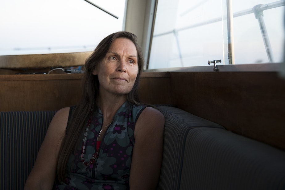 caption: Deborah Alexander, one of the many people who were tribally disenrolled from the Nooksack tribe, looks out of the window of a safety boat during the first leg of a canoe journey on Thursday, July 27, 2017, in Point Roberts.