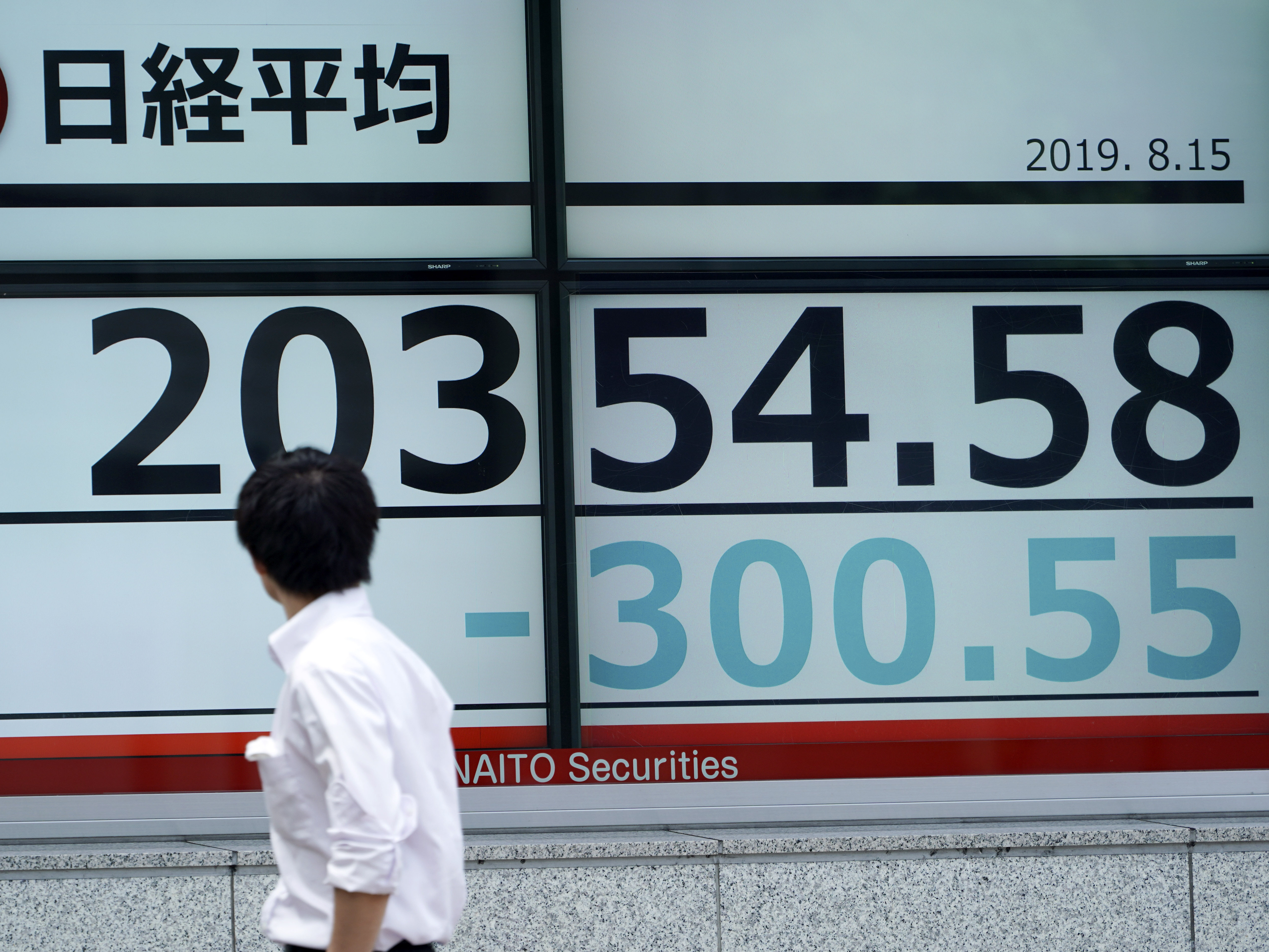 caption: A man looks at an electronic stock board showing Japan's Nikkei 225 index at a securities firm in Tokyo on Thursday.