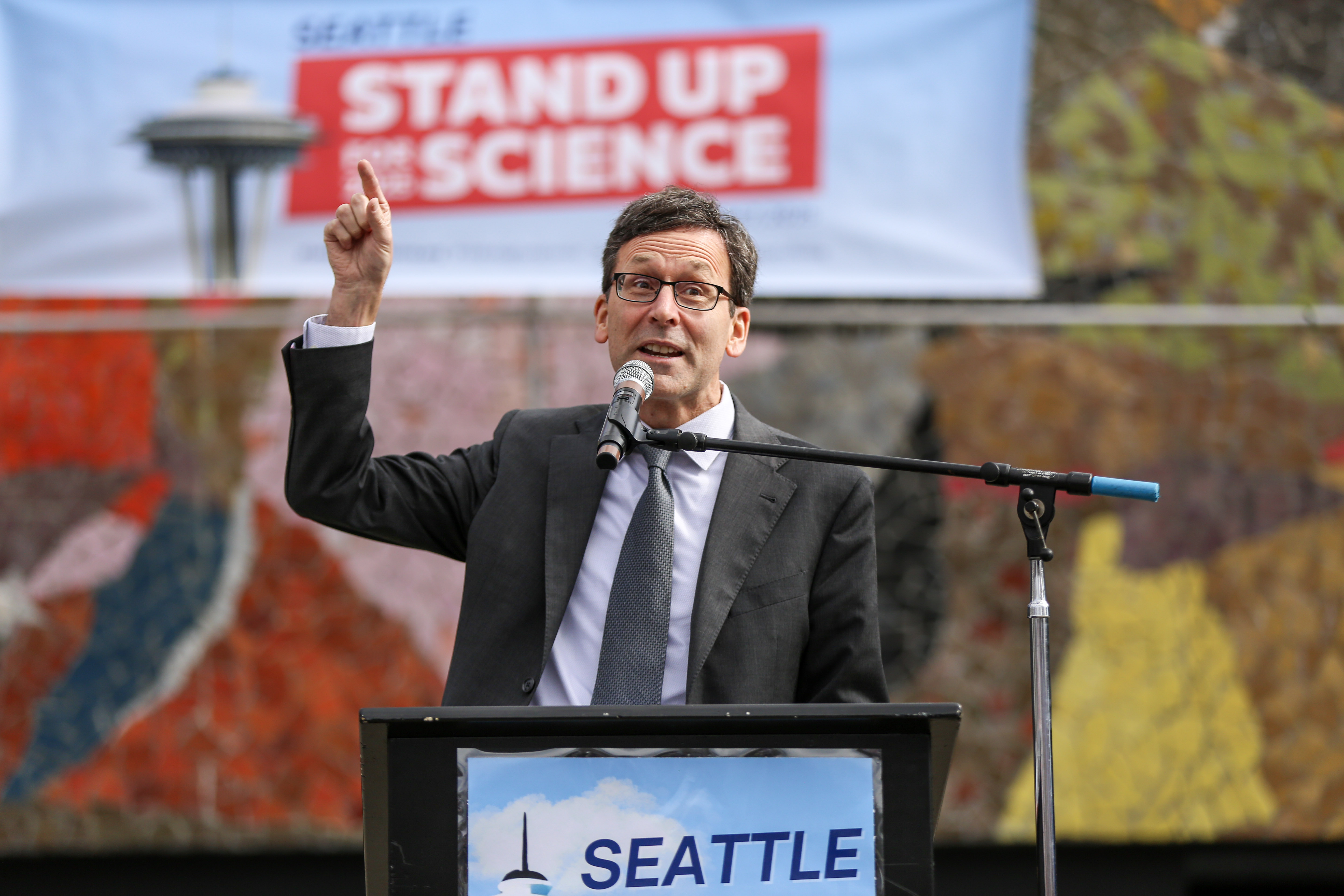 caption: Washington state Gov. Bob Ferguson speaks at the Stand Up for Science rally on March 7, 2025, in Seattle.