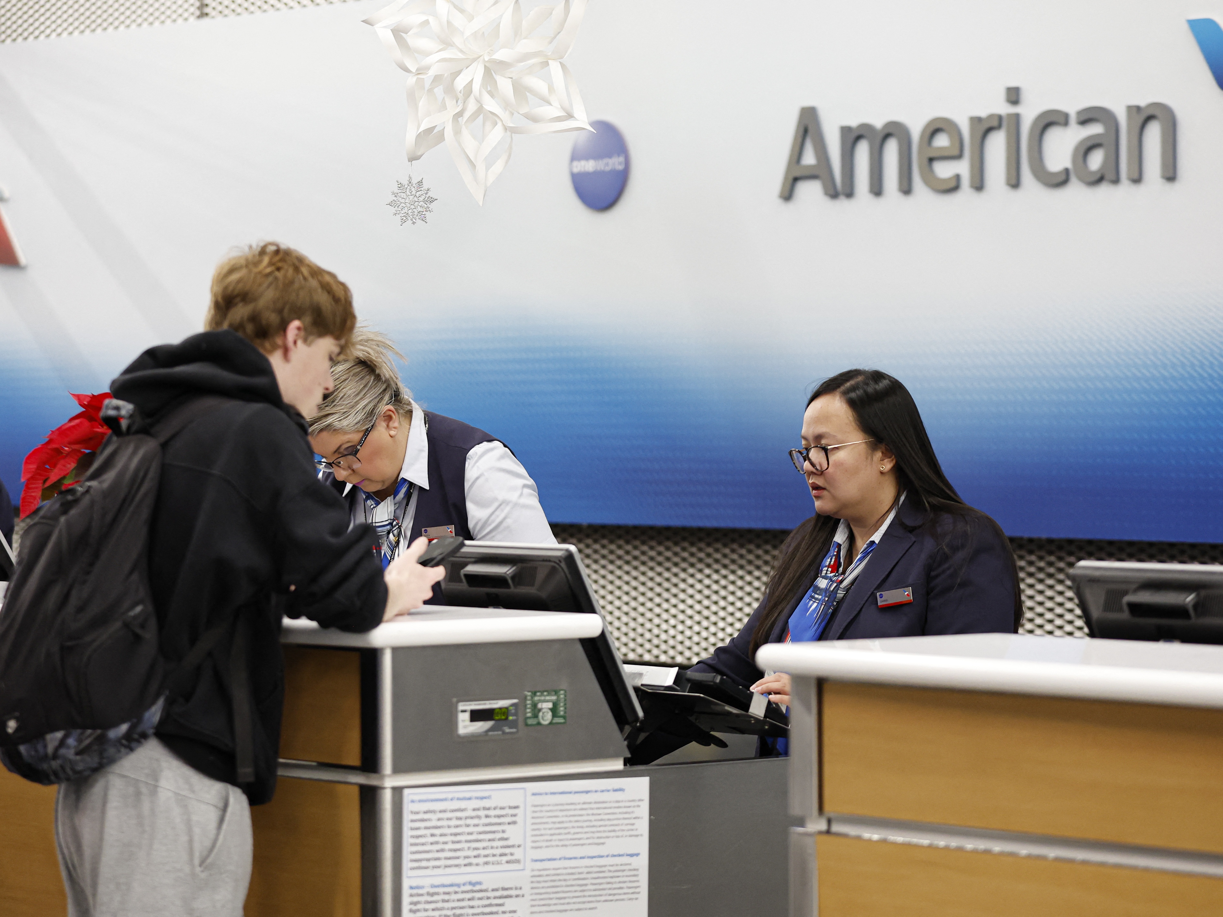caption: An American Airlines agent talks to a customer at O'Hare International Airport in Chicago, Ill., last week. On Tuesday, the airline issued a national halt to flights.