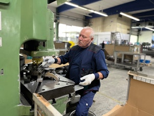 caption: A worker at Munk Group in Günzburg, Germany, punches holes into a part that will be used to construct a ladder. After years of using Chinese suppliers, Munk Group recently decided to cut off all business with China. Germany's government has cautioned all German businesses to be careful about not depending too heavily on China, a strategy known as "de-risking."