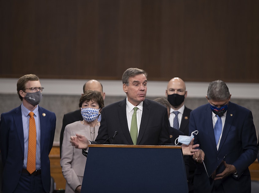 caption: Sen. Mark Warner (D-VA) speaks alongside a bipartisan group of Democrat and Republican members of Congress as they announce a proposal for a $908 billion Covid-19 relief bill on Capitol Hill on Dec. 01, 2020