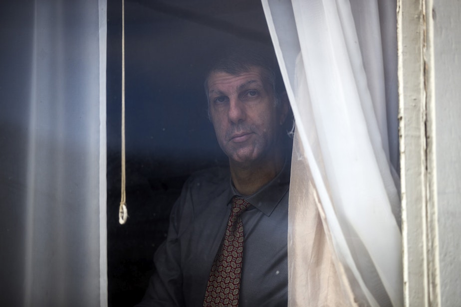 caption: Joe Dibee is portrayed while looking out of a window at his family's home on Wednesday, February 17, 2021, in Seattle.