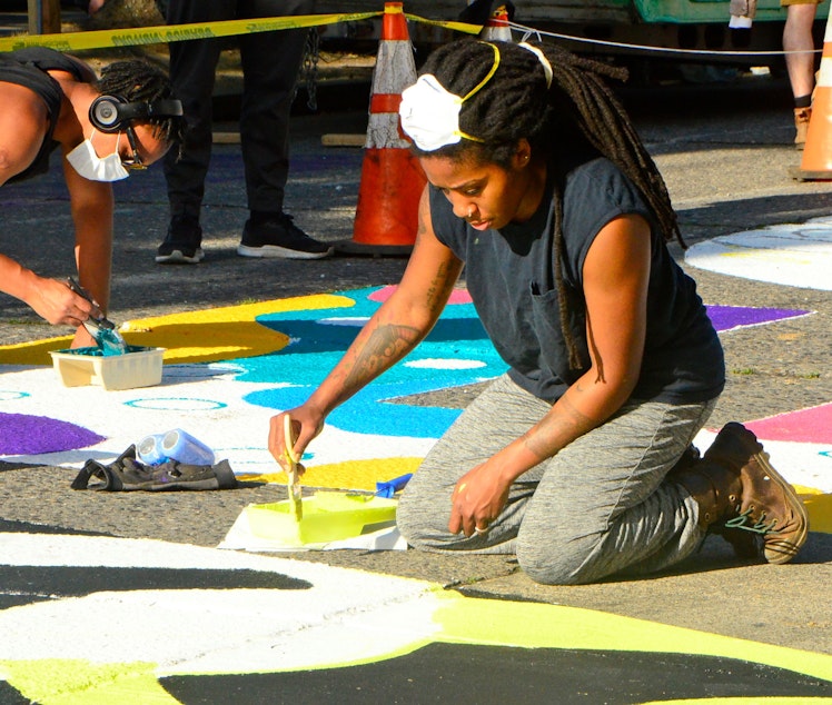 caption: Artist Aramis O. Hamer at work on the Black Lives Matter mural in the CHOP in Seattle.