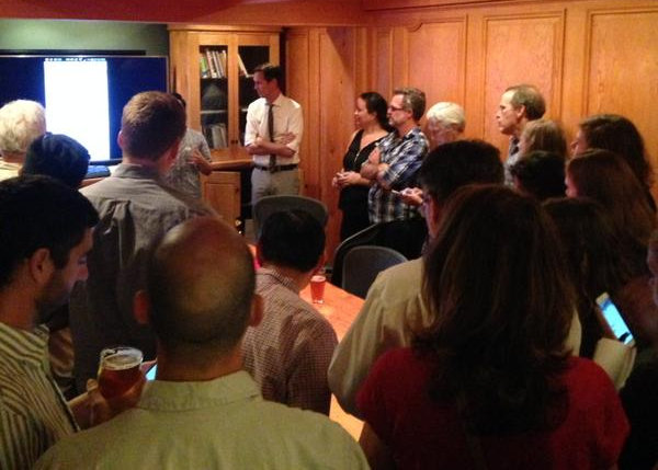 caption: Rob Johnson (center in light shirt and tie) and campaign supporters watch election results Tuesday night at The Pub at Third Place. Johnson was leading in District 4, ahead of Michael Maddux and incumbent Jean Godden.