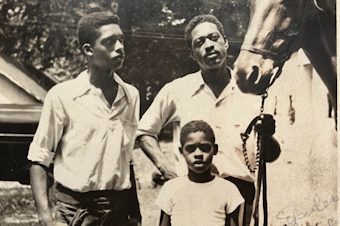 caption: A 10-year-old George Moxley (center) with his father (right) and older brother in Columbus, Ohio, in 1951.