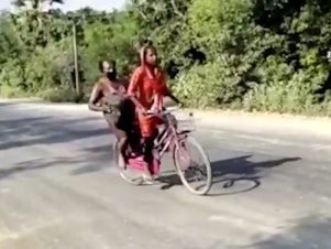 caption: In this screengrab from video posted by BBC News Hindi,15-year-old Jyoti Kumari's rides with her father during their 700 mile-long journey to their family's village of Sirhulli in eastern India.