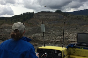caption: Brittany Duncan of Roboticists Without Borders flies a drone to survey the Oso mudslide on April 23, 2014.