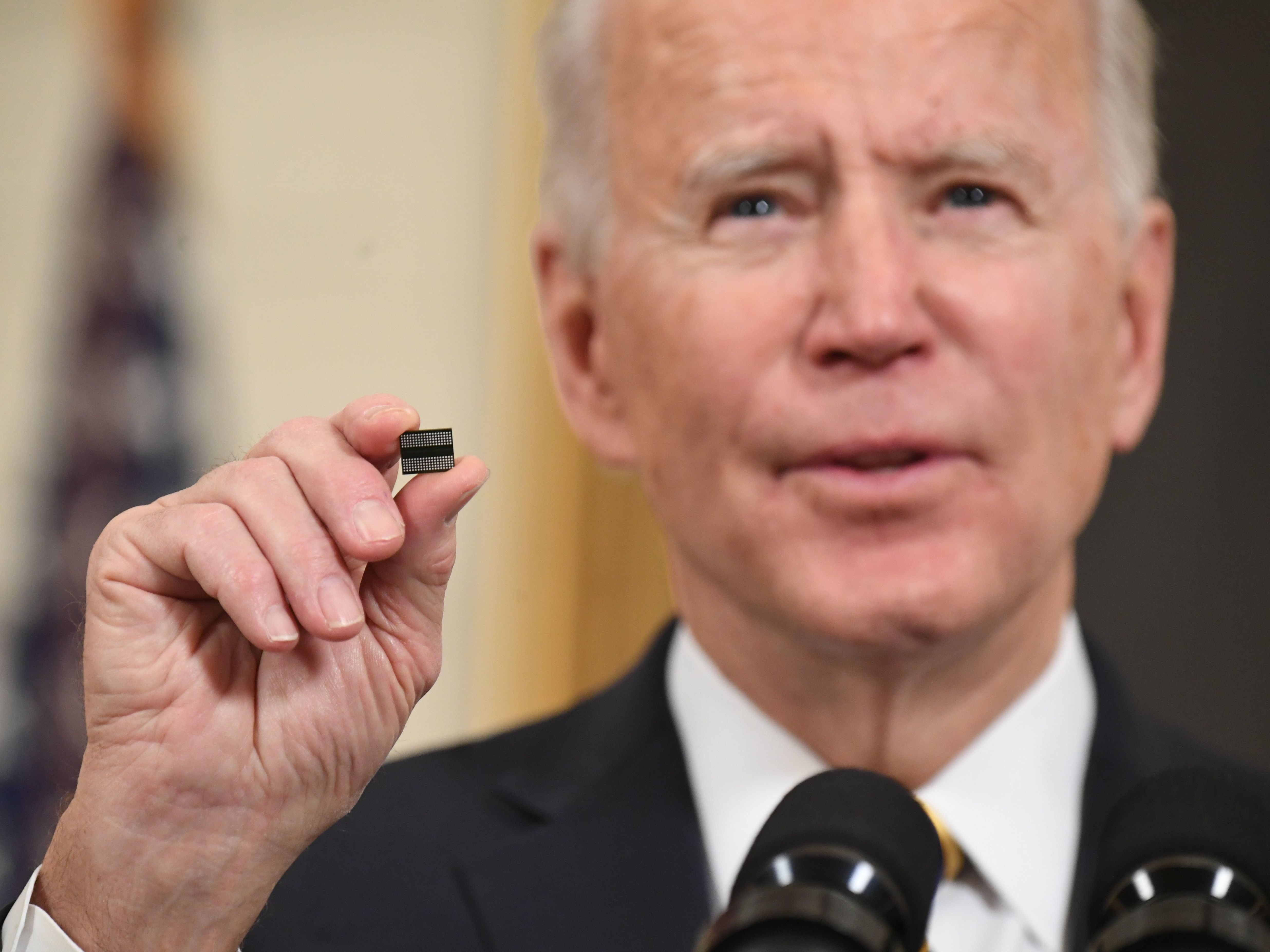 caption: President Biden holds a semiconductor chip in this 2021 file photo. The White House is working out how to spend $52 billion that Congress has provided to spur U.S. chip manufacturing plants.