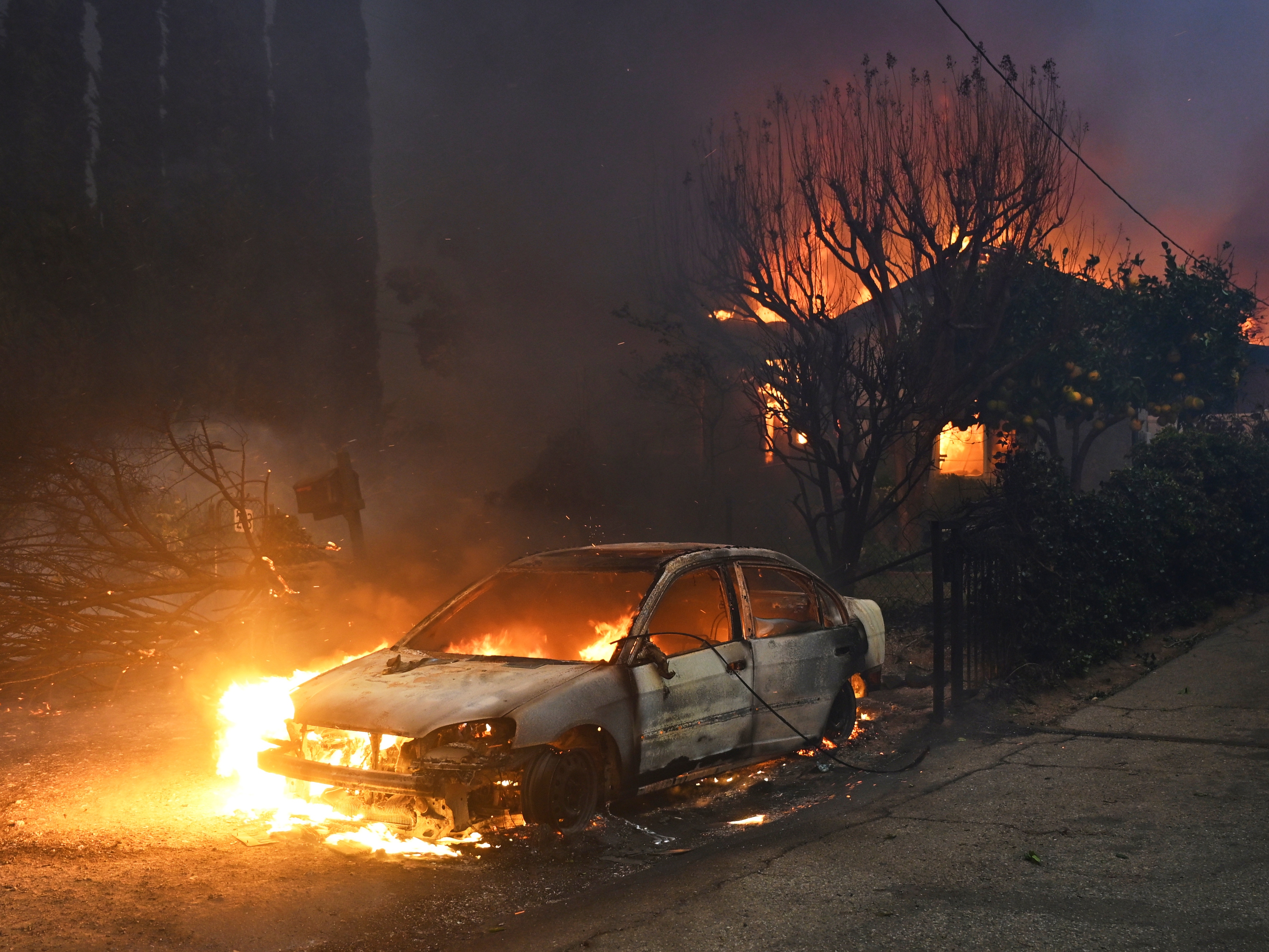 caption: FILE - The Eaton Fire burns vehicles and structures Wednesday, Jan. 8, 2025 in Altadena, Calif.