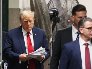 caption: Former President Donald Trump, left, following a recess at Manhattan criminal court in New York on Tuesday.