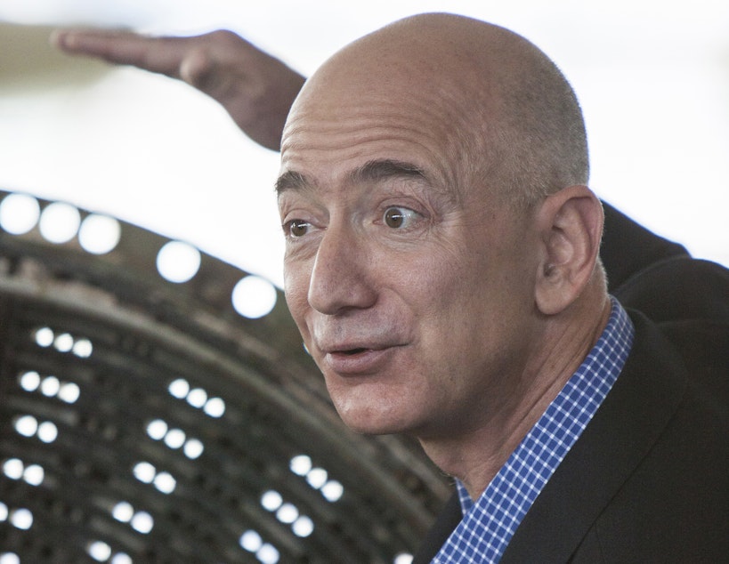 caption: Jeff Bezos speaks at the Apollo rocket engine unveiling at The Museum of Flight, showing the injector plate from an F-1 rocket used on Apollo 12.