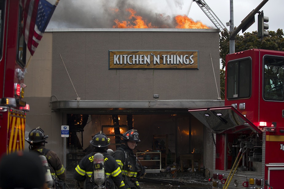 caption: Firefighters work to put out a fire at Kitchen 'N Things on Monday, October 7, 2019, at the intersection of NW Market Street and 24th Avenue Northwest in Seattle. 