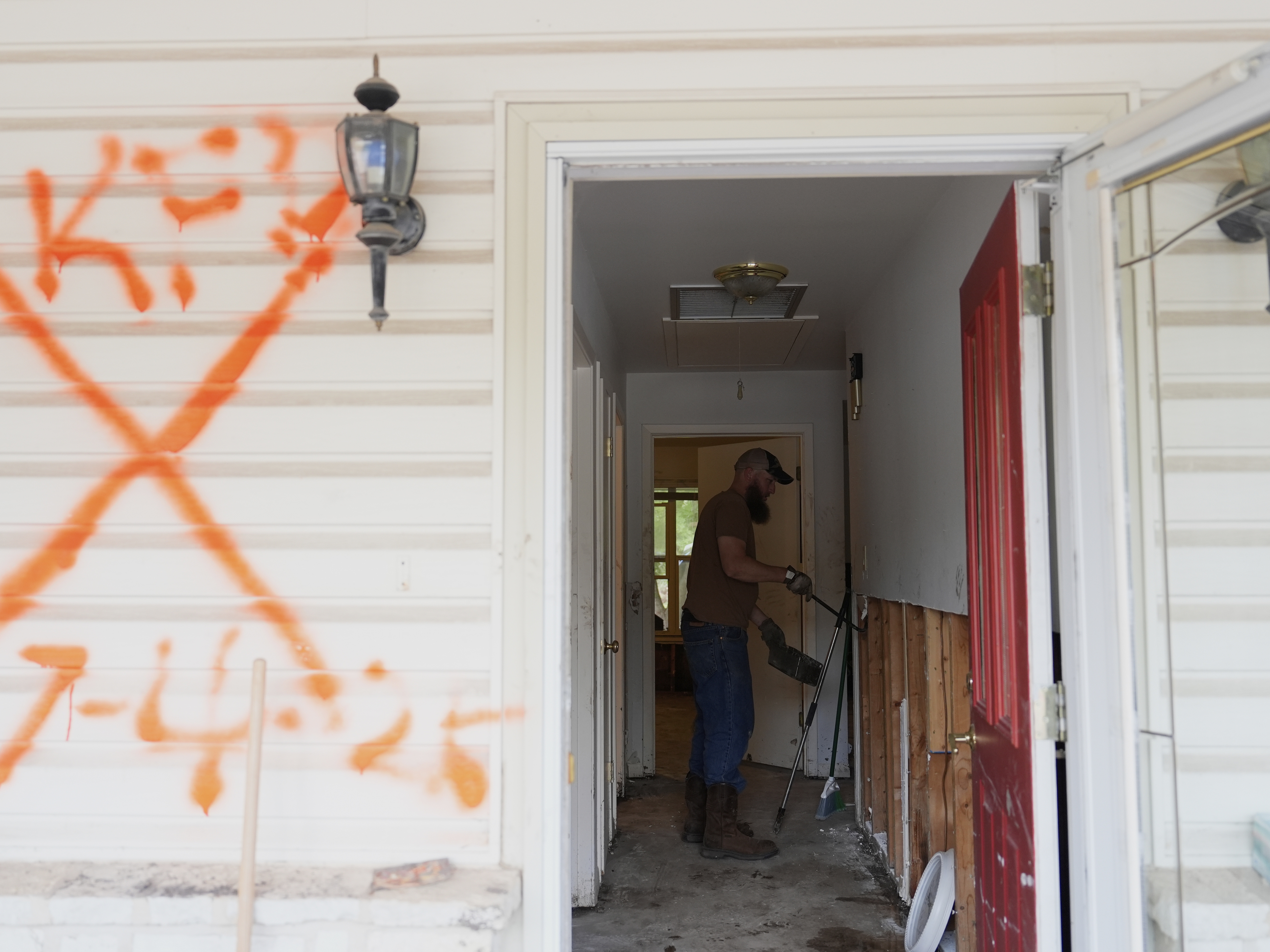 caption: Volunteers clean up a house after flooding in Kerrville, Texas. The state's governor and top emergency official are on a board considering options to eliminate the Federal Emergency Management Agency, at the request of President Trump.