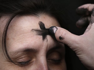 caption: The imposition of ashes on Ash Wednesday is accompanied by the admonition to "Remember that you are dust, and to dust you shall return."