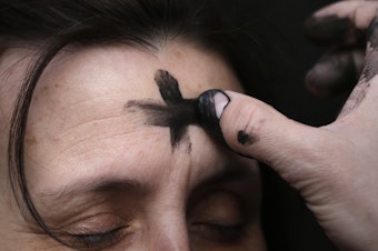 caption: The imposition of ashes on Ash Wednesday is accompanied by the admonition to "Remember that you are dust, and to dust you shall return."