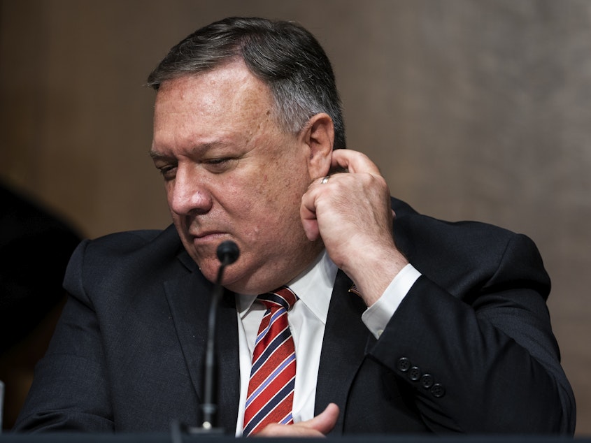 caption: Secretary of State Mike Pompeo testifies before a Senate Foreign Relations Committee hearing in July. The State Department has lifted its global health advisory warning against international travel.