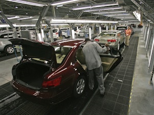 caption: Hyundai Motor Company employees put the finishing touches on vehicles in Montgomery, Ala.