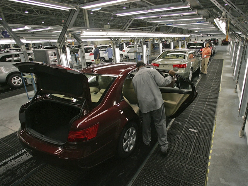 caption: Hyundai Motor Company employees put the finishing touches on vehicles in Montgomery, Ala.