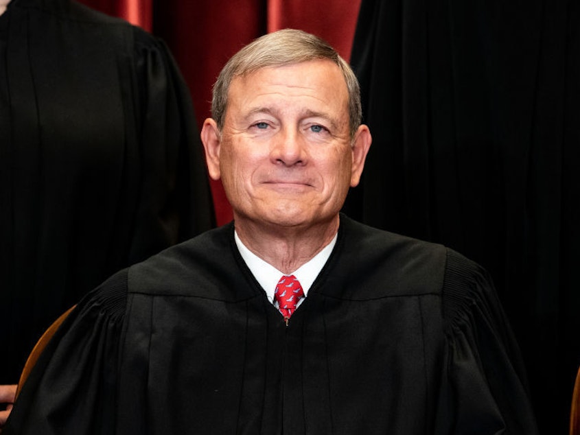 caption: Chief Justice John Roberts sits during a group photo of the Justices at the Supreme Court in 2021.