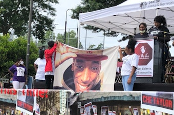 caption: Stephanie Butts, at the microphone, remembers her son Damarius Butts, as his siblings hold up his photo. The Office of Police Accountability is investigating why SPD had a tombstone with Butts' name sitting on a shelf in the East Precinct in 2021. 