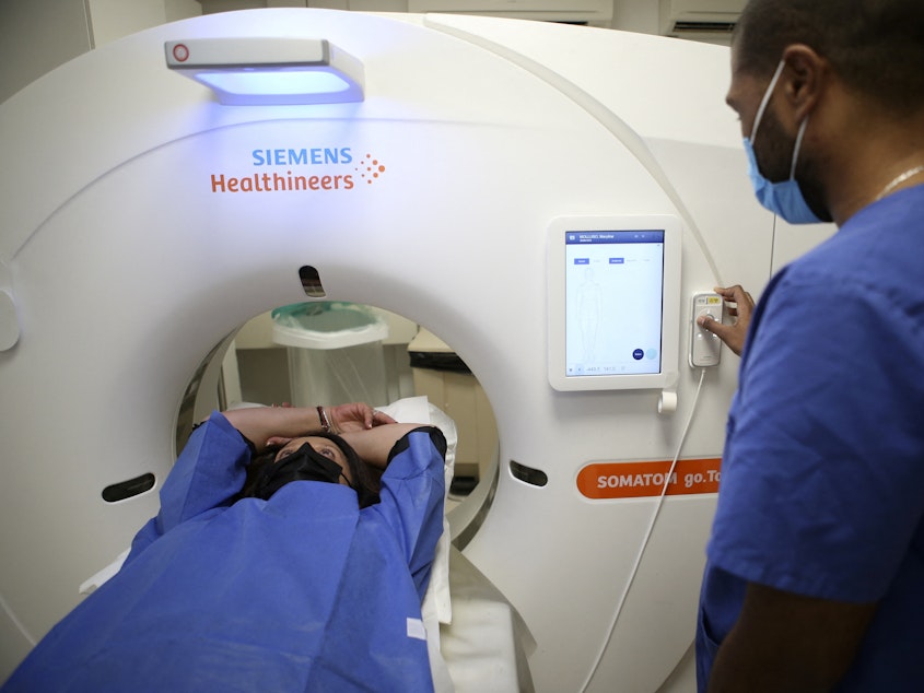 caption: A patient gets a low-dose CT scan to screen for lung cancer. The American Cancer Society on Wednesday recommended expanding who should have this annual screening test.