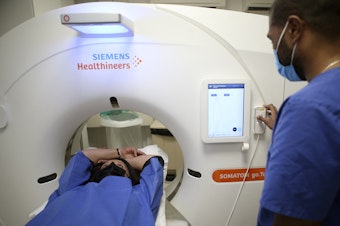 caption: A patient gets a low-dose CT scan to screen for lung cancer. The American Cancer Society on Wednesday recommended expanding who should have this annual screening test.