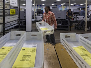 caption: Miami-Dade County elections workers begin counting Florida mail ballots on Nov. 8, 2022.