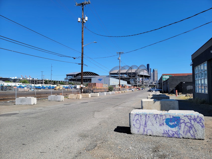 caption: Concrete blocks places by businesses to prevent RV parking line many of the streets and alleys in Seattle's SoDo neighborhood on Wednesday, July 19, 2023.